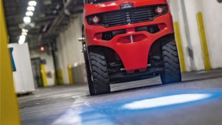 Linde Gegengewichtsstapler mit BlueSpot projiziert blauen Warnpunkt auf den Hallenboden