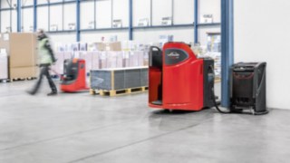 Niederhubwagen ausgerüstet mit Li-Ionen-Technologie von Linde an der Ladestation. Niederhubwagen ausgerüstet mit Li-Ionen-Technologie von Linde an der Ladestation.