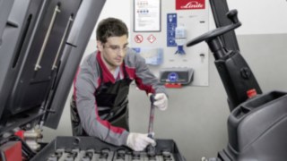 Ein Servicetechniker überprüft die Antriebsbatterie eines Linde Gebrauchtstaplers