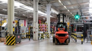 Stapler von Linde Material Handling vor einer Ampel des Assistenzsystems Linde Safety Guard Ein Stapler von Linde Material Handling wartet im Werk von Coca-Cola European Partners France vor einer Ampel des Linde Safety Guard.