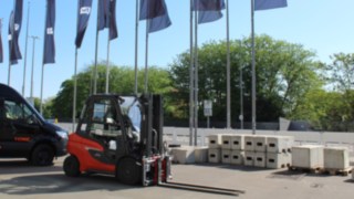 Ein roter Gabelstapler der Marke Linde vor den OMR-Flaggen 